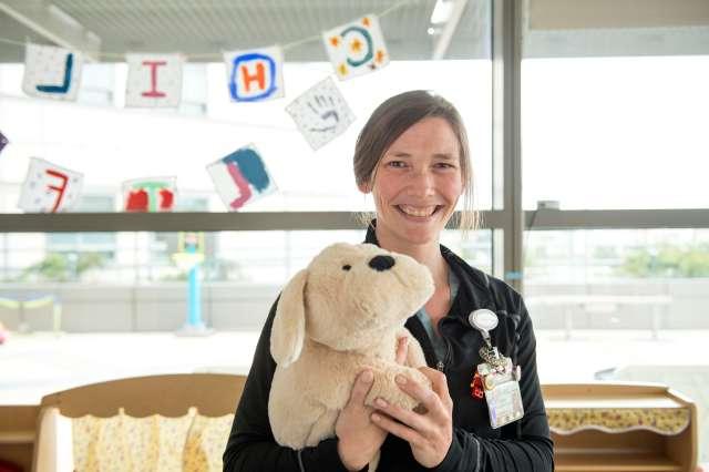 Woman smiling holding stuffed animal